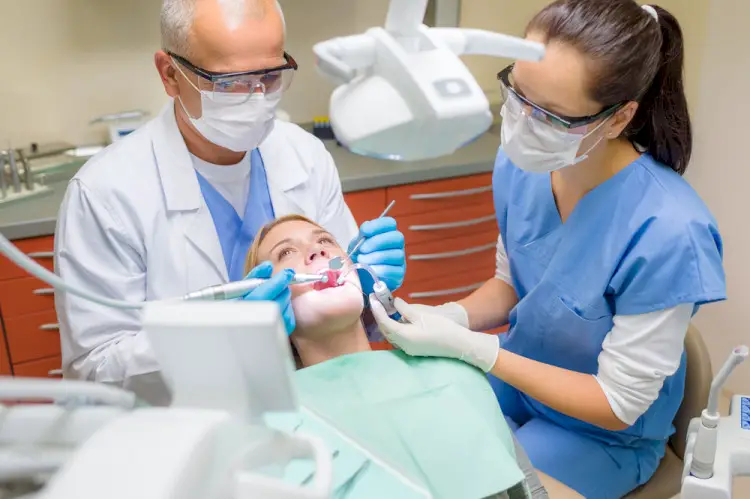 Dental assistant assisting dentist