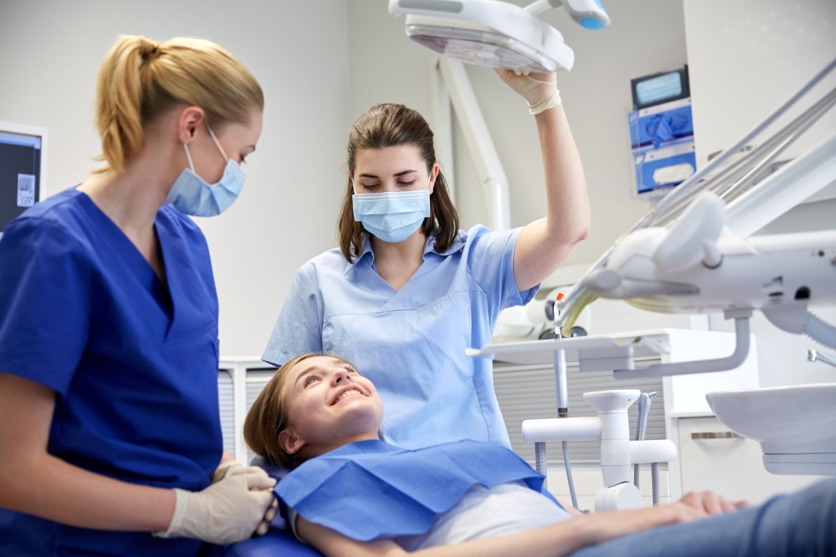 Dental assistant helping a dentist with a young patient